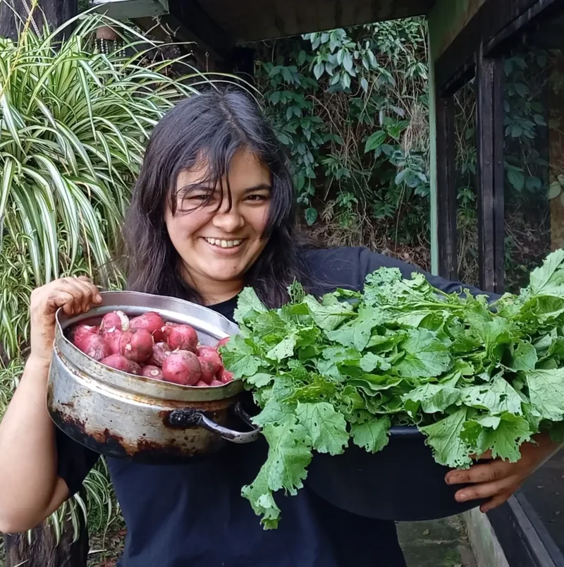 Jazmín Furlán con verduras cosechadas en la huerta