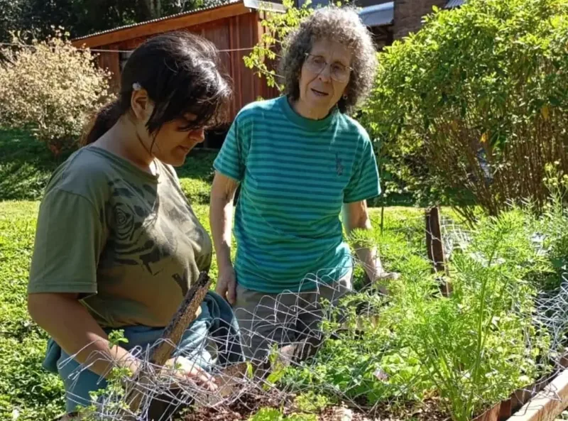 Jazmín Furlán trabajando entre plantas en la huerta